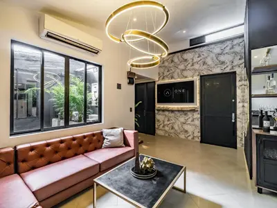 a living room with a couch and a chandelier at One Apartments Lleras in Medellín