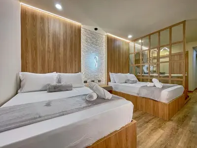 two beds in a room with wooden walls at One Apartments Lleras in Medellín