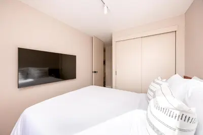 a white bedroom with a bed and a mirror at Magnífico apartamento de 2 habitaciones con AC y vistas en Provenza in Medellín