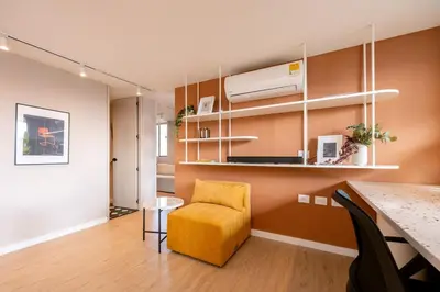 a living room with a yellow chair and a kitchen at Magnífico apartamento de 2 habitaciones con AC y vistas en Provenza in Medellín