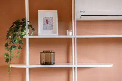 a white shelf with a candle and a picture at Magnífico apartamento de 2 habitaciones con AC y vistas en Provenza in Medellín
