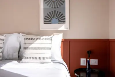 a bed with white pillows and a picture on the wall at Magnífico apartamento de 2 habitaciones con AC y vistas en Provenza in Medellín