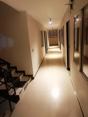a long hallway with white tile floors and stairs at Hotel Golden 70 in Medellín