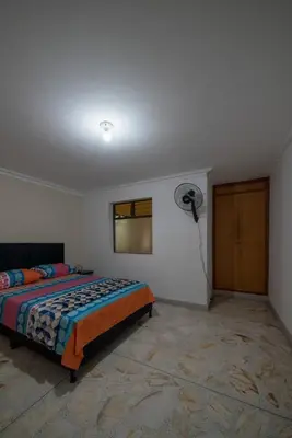 a bedroom with a bed and a fan at Your home away from home in Medellín