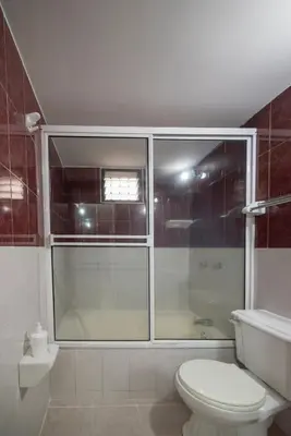 a bathroom with a toilet and a glass shower at Your home away from home in Medellín