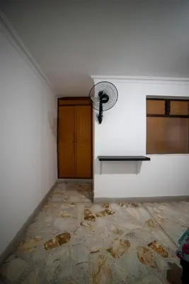 a room with a white wall and a table and a door at Your home away from home in Medellín