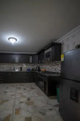 a kitchen with black cabinets and a stainless steel refrigerator at Your home away from home in Medellín