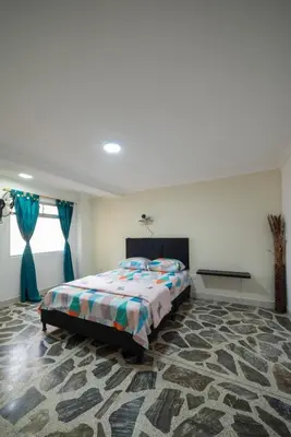a bedroom with a bed in a room with a rug at Your home away from home in Medellín