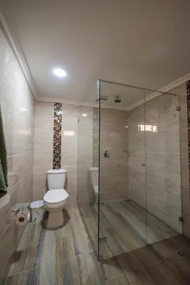 a bathroom with a toilet and a glass shower at Your home away from home in Medellín
