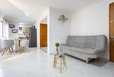 a living room with a couch and a kitchen at Parque de Envigado a 350 mts, 2bd, 500mb internet in Envigado