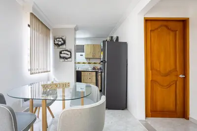 a kitchen with a glass table and a black refrigerator at Parque de Envigado a 350 mts, 2bd, 500mb internet in Envigado