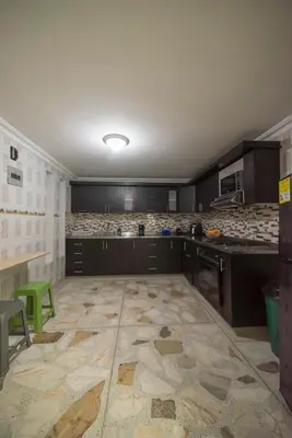 a kitchen with black cabinets and a tile floor at Belén Vibe in Medellín