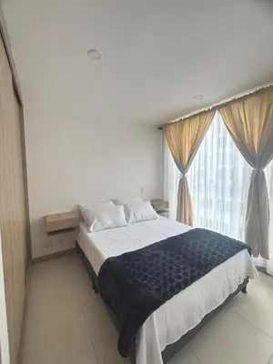 a bedroom with a bed and a large window at Acogedor y moderno apartamento en Manizales in Manizales