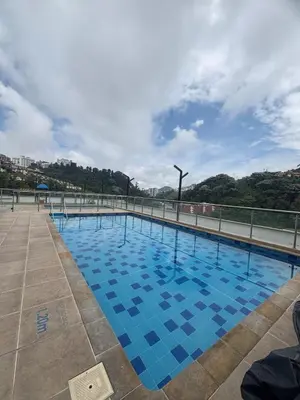 a large swimming pool with blue tiles on the ground at Acogedor y moderno apartamento en Manizales in Manizales