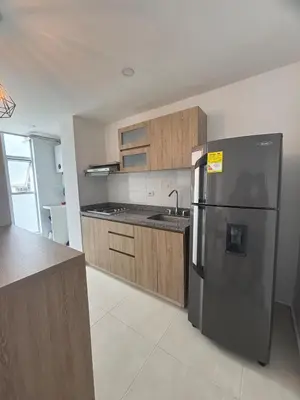 a kitchen with a stainless steel refrigerator and wooden cabinets at Acogedor y moderno apartamento en Manizales in Manizales