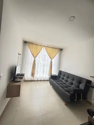 a living room with a black couch and a television at Acogedor y moderno apartamento en Manizales in Manizales