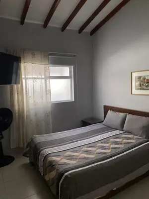a bedroom with a large bed with a window at Apartamento cerca al metro y viva envigado in Itagüí
