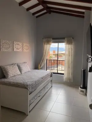 a bedroom with a bed and a large window at Apartamento cerca al metro y viva envigado in Itagüí