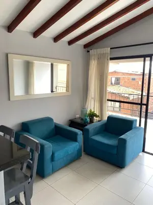 a living room with two blue chairs and a window at Apartamento cerca al metro y viva envigado in Itagüí