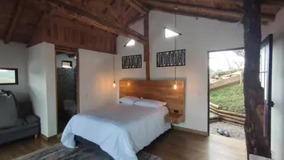 a bedroom with a bed and a large window at Chalet los naranjos in La Pradera