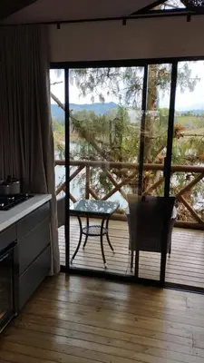 a kitchen with a large glass door with a table on a deck at Chalet los naranjos in La Pradera