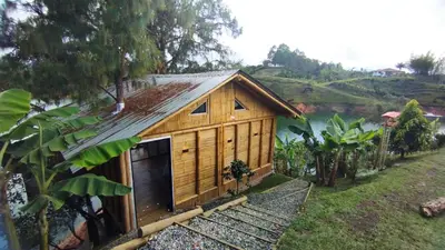 a wooden house with a garage next to a river at Chalet los naranjos in La Pradera