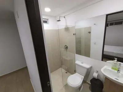 a bathroom with a toilet and a shower and a sink at Cloud9h in Medellín