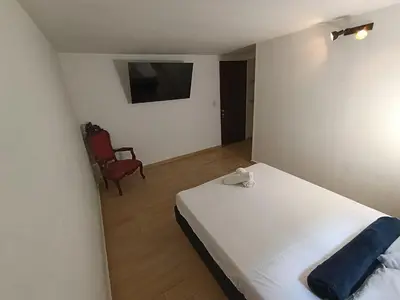 a small bedroom with a bed and a chair at Cloud9h in Medellín