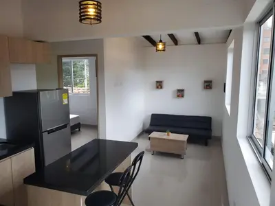 a kitchen and living room with a black counter top at Cloud9h in Medellín