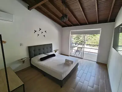 a bedroom with a bed with birds on the wall at Cloud9h in Medellín