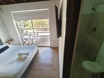 a bedroom with a bed and a bathroom with a shower at Cloud9h in Medellín