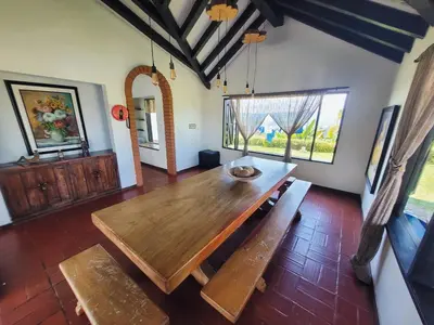 a dining room with a wooden table and benches at Finca Doña Ana in Palestina
