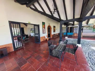 a living room with chairs and a table and a fireplace at Finca Doña Ana in Palestina