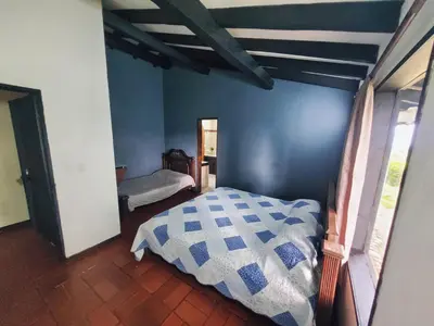 a bedroom with a bed with a blue wall at Finca Doña Ana in Palestina