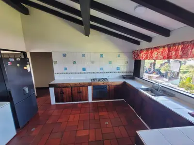 a kitchen with wooden cabinets and a large window at Finca Doña Ana in Palestina
