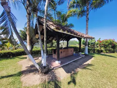 a gazebo in a park with palm trees at Finca Doña Ana in Palestina