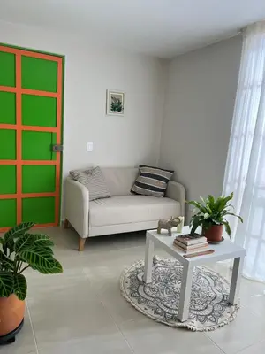 a living room with a couch and a table at Un apartamento cálido y céntrico rodeado de jardines in Guatapé