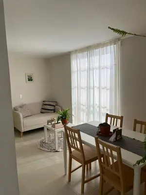 a living room with a table and a couch at Un apartamento cálido y céntrico rodeado de jardines in Guatapé