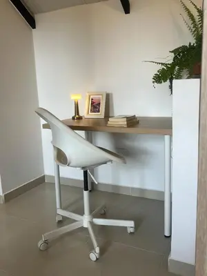 a white desk with a white chair and a table at Un apartamento cálido y céntrico rodeado de jardines in Guatapé