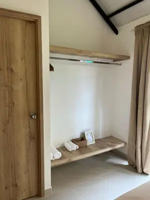 a room with a wooden shelf and a door at Un apartamento cálido y céntrico rodeado de jardines in Guatapé