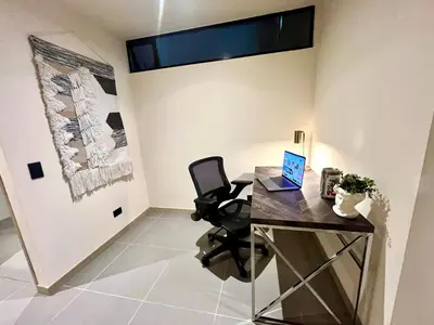 an office with a desk with a laptop on it at Designed 3-Bedroom Apartment & Office with 800 Wi-Fi, New Samsung Appliances in Envigado