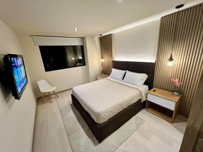 a bedroom with a bed and a flat screen tv at Designed 3-Bedroom Apartment & Office with 800 Wi-Fi, New Samsung Appliances in Envigado