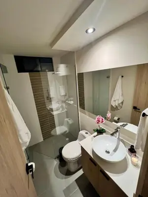 a bathroom with a sink and a toilet and a mirror at Designed 3-Bedroom Apartment & Office with 800 Wi-Fi, New Samsung Appliances in Envigado
