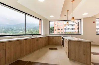 a kitchen with wooden cabinets and large windows at Designed 3-Bedroom Apartment & Office with 800 Wi-Fi, New Samsung Appliances in Envigado