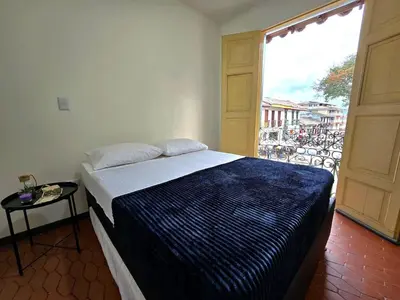 a bedroom with a bed and a large window at Rincon del Parque, Jerico - 2 Hab - 2 Cama Tarima - 1 Baño in Jericó