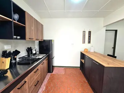 a kitchen with wooden cabinets and a black refrigerator at Rincon del Parque, Jerico - 2 Hab - 2 Cama Tarima - 1 Baño in Jericó