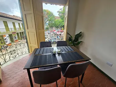 a table and chairs in a room with a balcony at Rincon del Parque, Jerico - 2 Hab - 2 Cama Tarima - 1 Baño in Jericó
