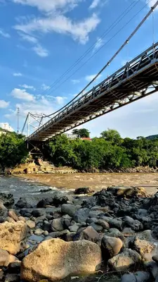 a bridge over a river with rocks at Mirador del Río in Honda