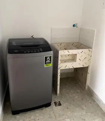 a kitchen with a dishwasher next to a small table at Casa Selva in San Carlos