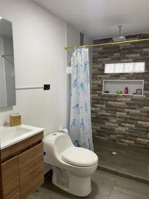 a bathroom with a toilet and a shower curtain at Villa Paulina in Ebéjico
